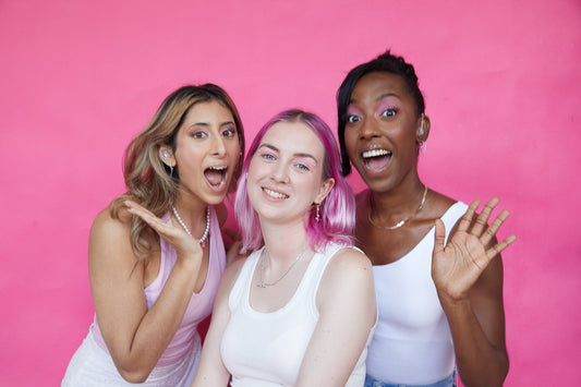 three girls are wearing gold huggie earrings