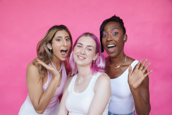 three girls are wearing gold huggie earrings
