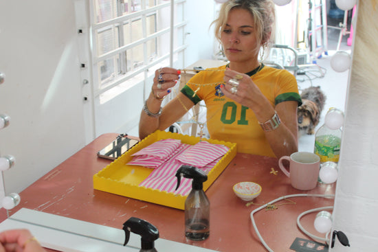 girl is holding 14k gold huggie hoop earrings