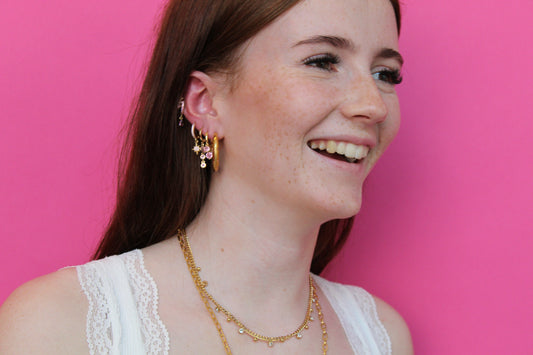 she is wearing gold huggie earring