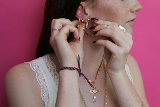 she is putting gold huggie earring