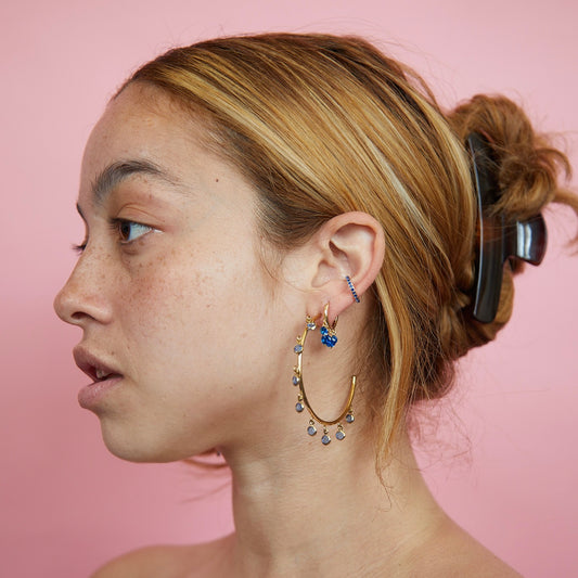 the girl is wearing gold huggie earring